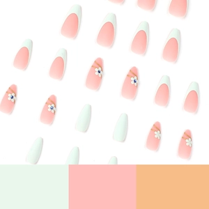 Green and pink press-on nails with white flower patterns and blue rhinestones