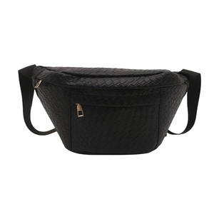 Close-up of black woven leather texture and gold zipper on a stylish belt bag