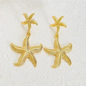 Golden starfish drop earrings with textured surface and minimalist marine jewelry design