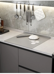 Close-up of a stainless steel kneading board with an L-shaped edge on a marble countertop