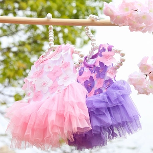 Detail of pink and purple floral pet dresses with layered mesh and pearl hangers