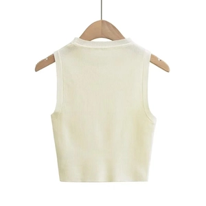 Detailed view of cream white sleeveless knit crop top with ribbed texture on a wooden hanger