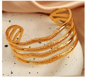 Detailed close-up of 18K gold-plated titanium steel wavy bracelet with hammered texture