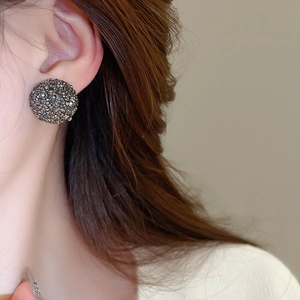 Gros plan sur mannequin portant des boucles d'oreilles cœur serties de strass gris
