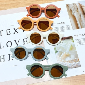 Kids round frame sunglasses in various Morandi colors shown on a fashion magazine