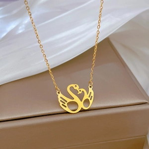 Close-up of golden kissing swan pendant necklace on a premium jewelry display box