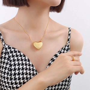 Elegant 18k gold heart pendant necklace and multi-layer rings on a fashion model