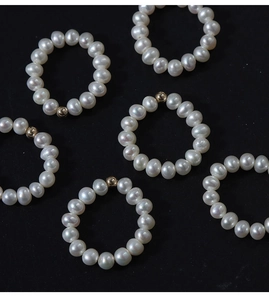 Detail of natural freshwater pearl rings with 14K gold filled beads on black background