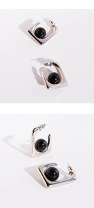 Detail view of square silver hoop earrings featuring a centered black sphere bead design