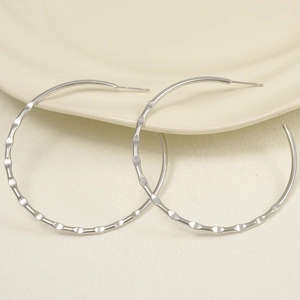 Detailed view of oversized wavy hammered silver stainless steel hoop earrings for women