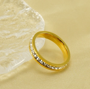 Gros plan d'une bague en acier doré avec une rangée incrustée de zircons cubiques clairs