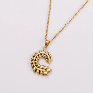 Detailed macro view of golden wheat ear leaf pendant necklace on thin chain