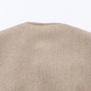 Gros plan sur la texture en laine et la couture du col de la veste couleur kaki