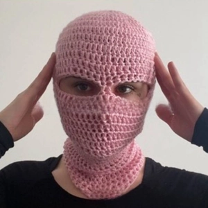 Detailed knit texture of a pink handmade full-face balaclava mask for winter warmth