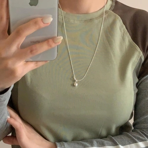 Simple silver heart pendant necklace shown on neck with minimalist style jewelry design