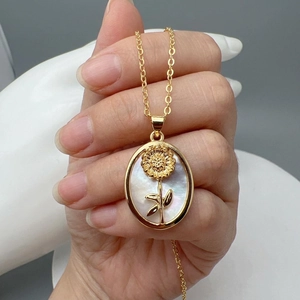 Elegant gold oval sunflower pendant necklace with iridescent white shell inlay detail