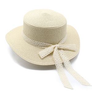 Elegant beige straw boater hat with delicate lace ribbon bow and flat top crown