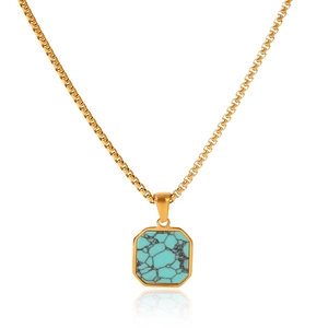 Detailed close-up of a gold necklace with an octagonal turquoise pendant on white background