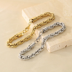 Detail of gold and silver twisted rope bracelets on natural stone texture background