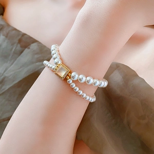 Detail of 18k gold plated double-layer pearl bracelet with square gemstone accent