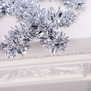 Macro shot of shimmering silver Christmas tinsel garland on an embossed white surface