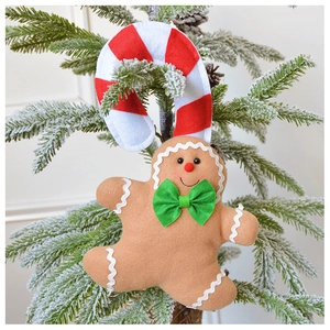 Close-up of plush gingerbread man and candy cane ornaments hanging on a Christmas tree