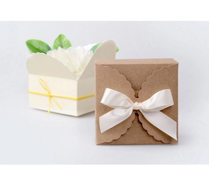 Detail of square handmade soap gift boxes with elegant ribbon bows and floral inserts