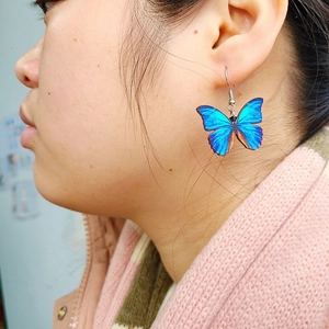 Elegant long blue butterfly wing earrings shown on model for a stylish bridal look