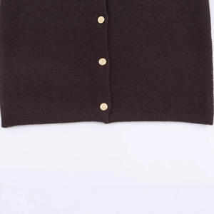 Knit cardigan featuring faux fur collar and decorative gold buttons on dark fabric