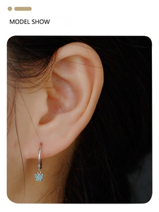 Close-up of S925 silver hoop earring featuring a dainty blue turquoise butterfly pendant