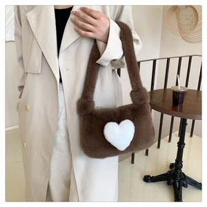 Detailed texture of brown plush shoulder bag featuring a white heart motif on a cozy material