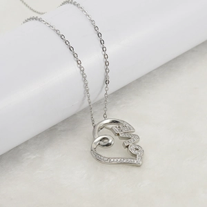 Silver stainless steel heart necklace with LOVE pendant and inlaid crystals on plush background