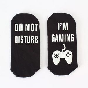 Detail showing non-slip letter printing and game controller icon on black cotton socks
