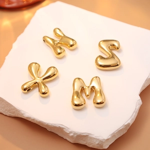 Minimalist 18K gold stainless steel bubble letter pendants on a decorative stone base