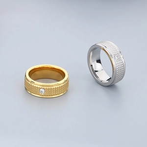 Close-up of textured titanium steel band with center zircon inlay in gold and silver