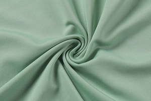 Close-up of sage green ribbed knit fabric showing soft texture and elastic drape