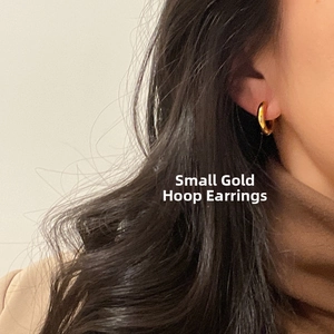 Close-up of small 18k gold plated stainless steel hoop earring worn by a model