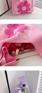Detailed view of pink and purple knitted gift bags with floral patterns and internal storage