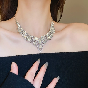 Dettaglio della collana a V in argento con diamanti a goccia su modella elegante