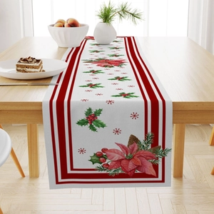 Linen Christmas table runner with poinsettia and holly berries on light wood table