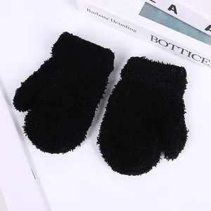 Close-up of thick black coral fleece mittens featuring elastic ribbed cuffs for children