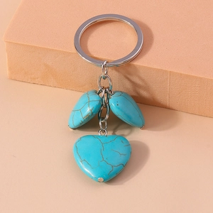Ethnic style heart and teardrop turquoise keychain with silver metal clip on beige stand
