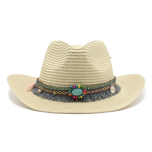 Détail d'un chapeau de cowboy en paille avec perles ethniques, pierre turquoise et pompon