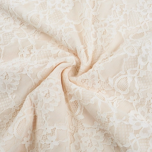 Close-up of white lace fabric featuring floral patterns and intricate mesh textures