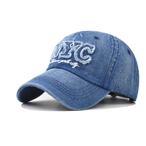 Washed blue denim baseball cap with white NYC embroidery in a 45-degree angle view