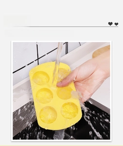 Detail of easy-to-clean yellow silicone mold being rinsed under water after use