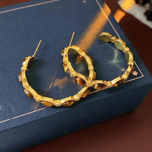 Dettaglio degli orecchini vintage placcati oro con occhio di tigre e perle fini