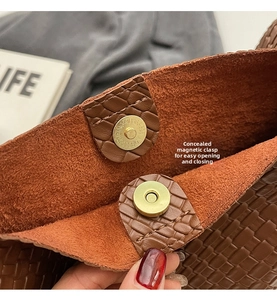 Close-up of woven leather shoulder bag showing secure magnetic buckle and interior texture