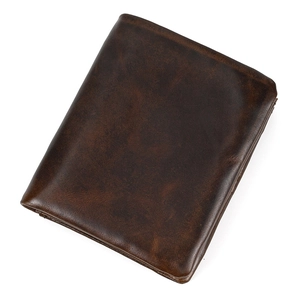 Close-up of premium dark brown genuine leather texture on a minimalist bifold wallet