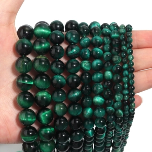 Detailed close-up of natural green tiger eye stone beads in various sizes for DIY jewelry